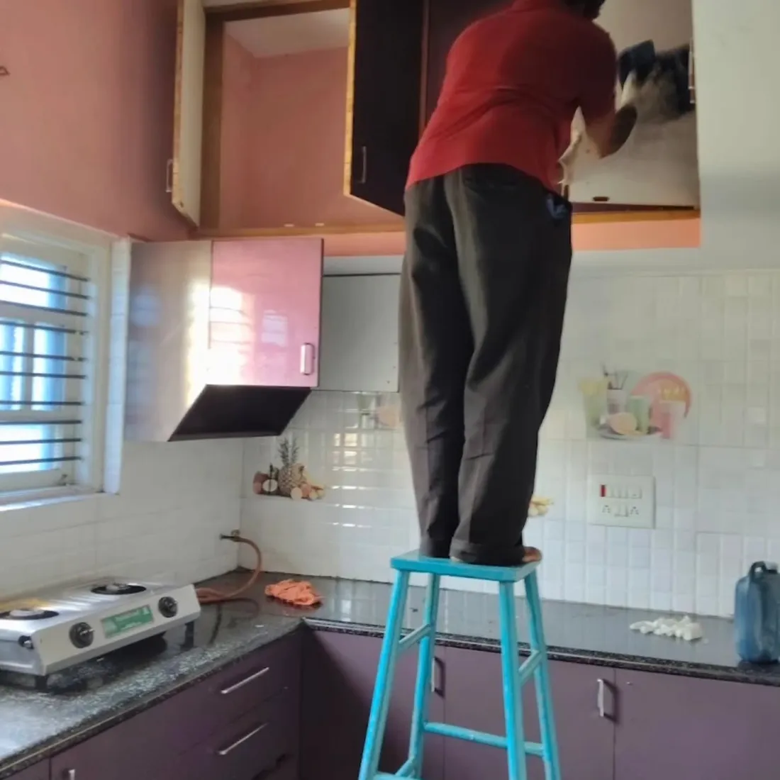 Team member deep cleaning kitchen cabinets