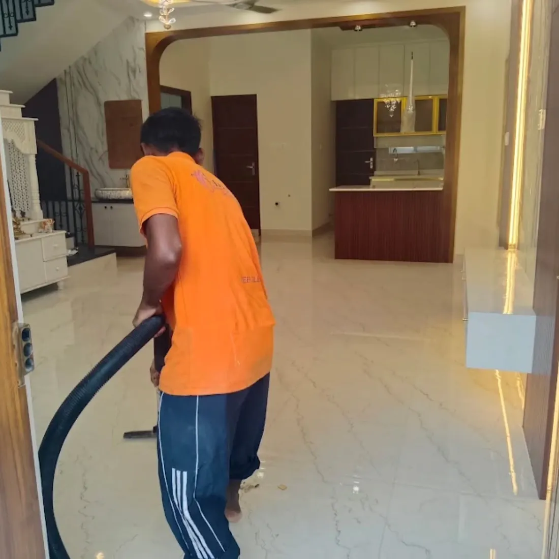 Cleaner vacuuming a marble floor